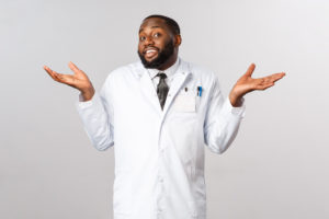 Coronavirus, covid19 and healthcare concept. Dont know cant help sorry. Portrait of reluctant, unbothered handsome african-american doctor shrugging clueless, puzzled and have no idea.