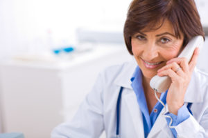 Senior female doctor calling on phone, smiling.