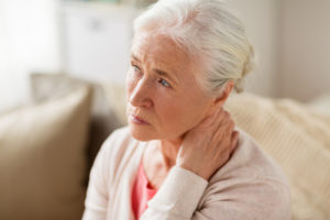 old age, health problem and people concept - senior woman suffering from neck pain at home