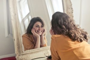 Woman looking at herself satisfactorily in the mirror