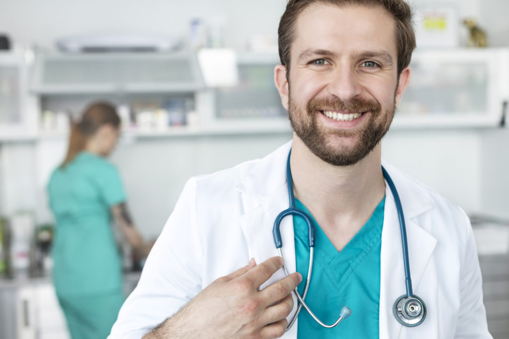 Portrait of smiling doctor standing against coworker at veterinary clinic