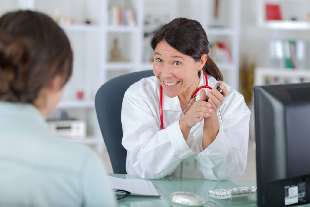 doctor talking to woman patient in office